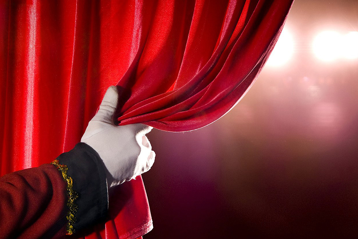 mano che apre tendone da teatro
